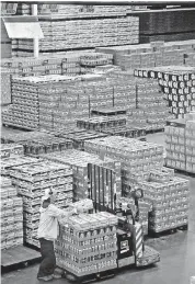  ??  ?? An employee loads a lift in the 100,000-square-foot AnheuserBu­sch Sales of Oklahoma distributo­r facility in Oklahoma City.