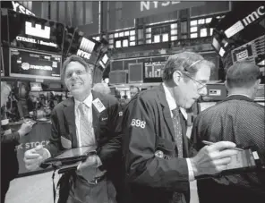  ?? Bloomberg News/ MICHAEL NAGLE ?? Traders work Monday on the fl oor of the New York Stock Exchange.
