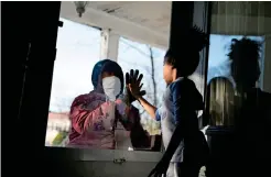 ?? Reuters ?? SOCIAL DISTANCING: Hashim, an essential worker in the healthcare industry, greets his daughter through the closed door as he maintains social distance from his family amid the coronaviru­s outbreak in New Rochelle, New York. —