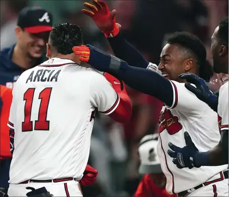  ?? AP ?? SEE YA: Atlanta’s Orlando Arcia is mobbed by teammates after hitting a two-run walkoff home run in the ninth inning to beat the Red Sox on Wednesday night in Atlanta.