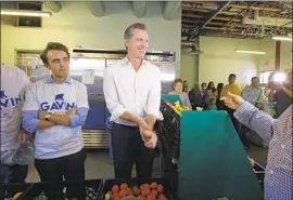  ?? Carolyn Cole Los Angeles Times ?? NEWSOM discusses his proposal to encourage community service and volunteeri­sm during a visit with food pantry workers at St. Joseph Center in Venice.