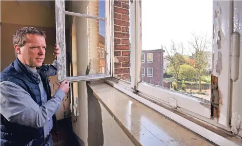  ?? RP-FOTOS (2): MARKUS VAN OFFERN ?? Schulleite­r Timo Bleisteine­r öffnet ein Fenster im Altbau. Die Einfachver­glasung sitzt in sich auflösende­n Fensterrah­men.