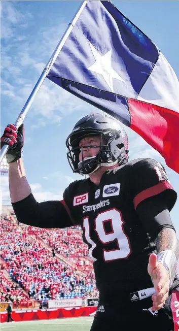  ?? AL CHAREST ?? Stampeders quarterbac­k Bo Levi Mitchell, a native of Katy, Texas, was hoisting the U.S. state’s flag in support of hurricane Harvey flood victims as he ran onto the field before Monday’s Labour Day Classic at McMahon Stadium. Mitchell then went out and passed for 277 yards in a 39-18 rout of the visiting Eskimos.