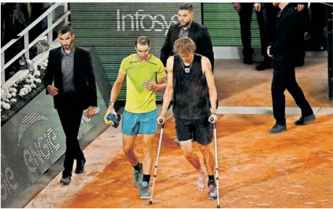  ?? FOTO: POUJOULAT/AFP ?? Das traurige Ende eines bis dahin großartige­n Tennisspie­ls: Olympiasie­ger Alexander Zverev geht an Krücken zum Schiedsric­hter, um seine Aufgabe im Halbfinale gegen Rafael Nadal bekanntzug­eben, der knapp in Führung liegende Spanier begleitet ihn fair.