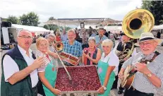  ?? FOTO: U. MISERIUS ?? Bernd Boitz (l.), Vorsitzend­er des SV Trompete, stößt mit einem Glas Erdbeerbow­le an. Der leckere Kuchen war schon nachmittag­s ausverkauf­t.