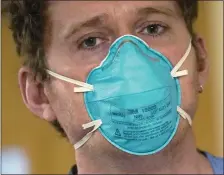  ?? ELAINE THOMPSON/THE ASSOCIATED PRESS ?? Registered nurse Scott McGieson wears an N95mask as he walks out of a patient’s room in the acute care unit of Harborview Medical Center in Seattle on Aug. 14, 2021.