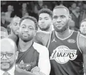  ??  ?? All-Star teammates Dwyane Wade of the Heat and LeBron James of the Lakers look on during the trophy presentati­on ceremony during the NBA All-Star Game.