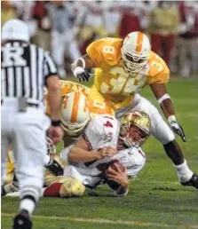  ?? AP PHOTO/MARK HUMPHREY ?? Florida State quarterbac­k Marcus Outzen is sacked by Tennessee’s Roger Alexander, top, and Billy Ratliff during the Fiesta Bowl on Jan. 4, 1999, at Sun Devil Stadium in Tempe, Ariz. The Vols won the BCS national championsh­ip that night, and Ratliff helped them get to that point undefeated with his heads-up fumble recovery against Arkansas on Nov. 14, 1998, during the regular season.