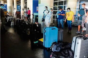  ??  ?? Safety measures: Luggage belonging to passengers who have just arrived at KLIA being sanitised to prevent the spread of Covid-19. — Bernama