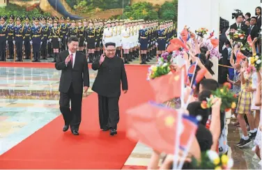  ?? Shen Hong / AFP / Getty Images / Xinhua News Agency ?? China’s President Xi Jinping (left) leads a welcoming for North Korean leader Kim Jong Un in Beijing.