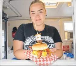  ??  ?? Tiffany MacIsaac, cashier and waitress at Winnie’s Wagon in Little Bras d’Or, is pictured with their special burger known as The Bernie Campfire Burger. The burger is part of this year’s Bartown Burger Battle event, which runs until Sunday on the...