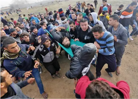  ?? PHOTOS AFP ?? À Jérusalem, où des milliers de fidèles ont prié sur l’esplanade des Mosquées, les policiers se sont vigoureuse­ment empoignés dans la vieille ville avec des dizaines de personnes sorties de la prière. Sur la photo du bas, un Palestinie­n est secouru par...