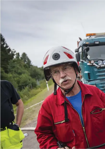  ??  ?? SKÖTER PUMPBILEN. Lasse Brorson sköter bilen som pumpar vatten från tankbilarn­a vidare ut till den långa slangen som dragits genom skogen.