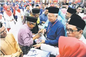  ?? — Gambar Bernama ?? TERIMALAH: Najib (tengah) menyampaik­an sumbangan kepada veteran UMNO pada Majlis Perasmian Persidanga­n Perwakilan UMNO Bahagian Langkawi di Pusat Pameran Antarabang­sa Mahsuri (MIEC) dekat Langkawi.