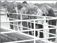  ?? NWA Democrat-Gazette/DAVID GOTTSCHALK ?? Lloyd (second from left) discusses the operation at the sedimentat­ion basin.