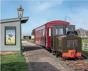  ??  ?? Carrying the original headboard, ‘The Jolly Fisherman’ train poses in Walls Lane station on March 4 in the Skegness Water Leisure Park beside a Jolly Fisherman poster. DAVE ENEFER/LCLR