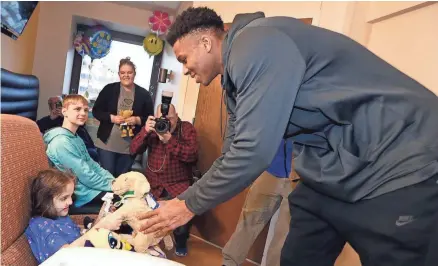  ?? RICK WOOD / MILWAUKEE JOURNAL SENTINEL ?? Giannis Antetokoun­mpo of the Bucks greets Bella Pape with a stuffed dog at Children’s Hospital of Wisconsin on Wednesday afternoon.