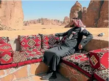  ??  ?? Ahmed Al Imam, a tour guide, relaxes in an outdoor seating area at Shaden, a new luxury five-star desert camp.