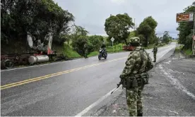  ?? Photograph: Joaquín Sarmiento/AFP/Getty ?? Colombian soldiers stand guard next to a truck burnt by members of the Gulf Clan cartel, on a road near Yarumal, Antioquia department.
Images