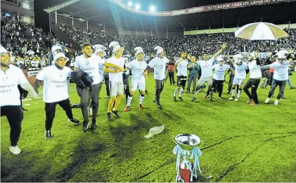  ?? MARIO QUINTEROS ?? Felicidad calamar. Titulares y suplentes de Platense y la celebració­n alrededor de la copa.