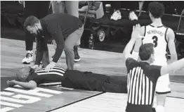  ?? MICHAEL CONROY AP ?? Referee Bert Smith is attended to after collapsing on the court during the first half of an Elite Eight game between Gonzaga and USC on Tuesday night.