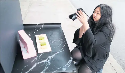  ?? RICHARD LAUTENS TORONTO STAR ?? WeChat influencer Joanna Luo shoots photos of Deercake’s pineapple cakes. She has more than 100,000 followers, mainly female internatio­nal Chinese students.