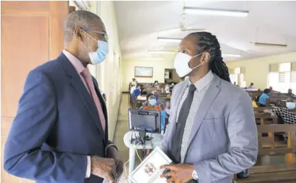  ?? (Photo: JIS) ?? Minister of state in the Ministry of Culture, Gender, Entertainm­ent and Sport Alando Terrelonge (right) greets pastor of the Constant Spring Road Church of God in Kingston Reverend W George Lewis. The occasion was Internatio­nal Men’s Day service held at the church yesterday.