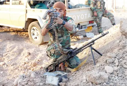  ??  ?? A Kurdish Peshmerga fighter checks his weapon, north of Kirkuk, Iraq. (Reuters)