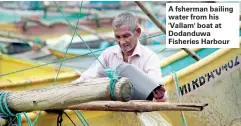  ??  ?? A fsherman bailing water from his 'Vallam' boat at Dodanduwa Fisheries Harbour