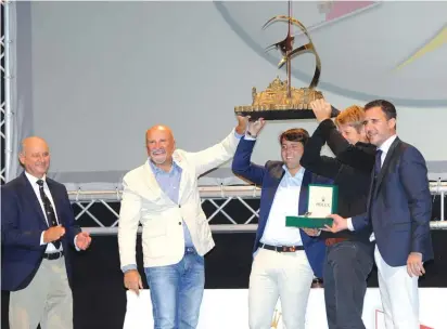  ??  ?? Mascalzone Latino owner Vincenzo Onorato, skipper Matteo Savelli and navigator Ian Moore with the Rolex Middle Sea Race Trophy. They are flanked by Godwin Zammit, Royal Malta Yacht Club Commodore, left, and Malcolm Lowell, representa­tive of Rolex in...