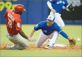  ?? The Canadian Press ?? St. Louis Cardinals’ Randy Arozarena slides in with a stolen base as the ball gets past Toronto Blue Jays second baseman Danny Espinosa during fifth-inning spring training MLB action on Monday in Montreal.The Blue Jays lost 5-3.