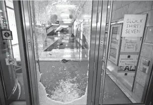  ?? CHARLES REX ARBOGAST/ASSOCIATED PRESS ?? A door to the Block 37 retail building is shattered Monday after vandals struck overnight in Chicago’s famed Loop. Chicago’s police commission­er said more than 100 people were arrested and several were officers injured.