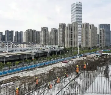  ?? ?? Strong support: In this file picture, workers are seen at a constructi­on site in Shanghai. Authoritie­s have sought to defuse the property crisis with a raft of measures, including cutting interest rates and offering special loans to ensure projects are delivered.