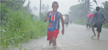  ?? Photo: Simione Haravanua ?? Lemeki Lausanacol­o crossing the flooded Vuci Road on January 20, 2019.