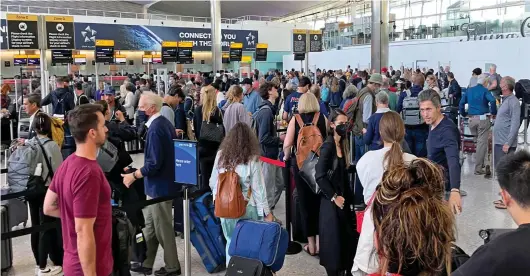  ?? ?? The new normal? Crowds of travellers waiting in line with their luggage to check in at Heathrow’s Terminal 2 yesterday