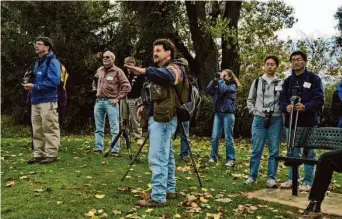  ?? DALE W. SYM ?? Above: Lodi Sandhill Crane Festival attendees watch for the birds on one of the many crane tours. Right: A crane dances in a photo titled “Happy Feet.” Cranes are known for their courtship dances.