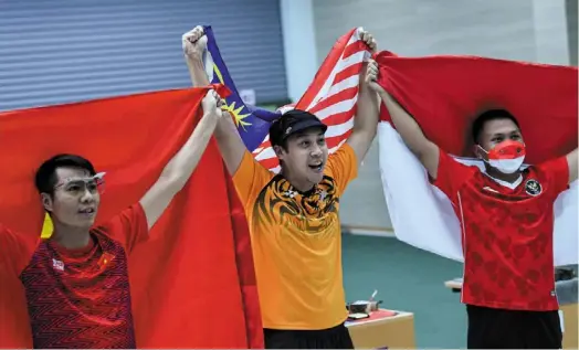  ?? ?? Well done!: Johnathan Wong (centre) celebratin­g on the podium after winning the 10m air pistol. Together with him are silver medallist Quoc Tran Cuong (left) of Vietnam and indonesia’s Muhammad Prabowo. — Bernama