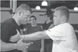  ?? MARK HENLE/THE REPUBLIC ?? Former Cardinals offensive lineman Scott Peters (left) teaches proper blocking techniques to Prescott High School lineman Quinten Cooley in 2008.