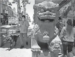  ?? ERIC RISBERG/AP ?? People make their way past the Dragon Gate southern entrance to Chinatown in San Francisco on May 23. Chinatowns and other Asian American enclaves across the U.S. are using art and culture to show they are safe and vibrant hubs nearly three years after the start of the pandemic.