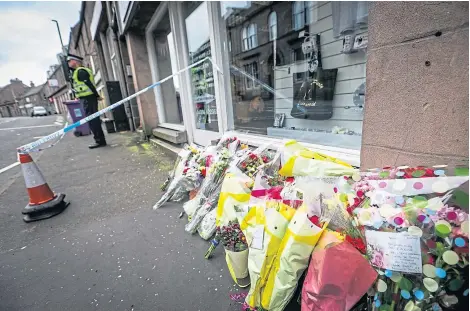  ?? Picture: Mhairi Edwards. ?? Police outside the property near where tributes were left for Neomi Smith last June.