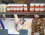  ??  ?? An employee stocks a display case at Gadaleto’s Seafood Market.