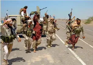  ?? AFP ?? Pro-government forces raise their weapons as they advance in the coastal town of Mokha in a bid to drive the Houthi rebels away from the Red Sea coast. —