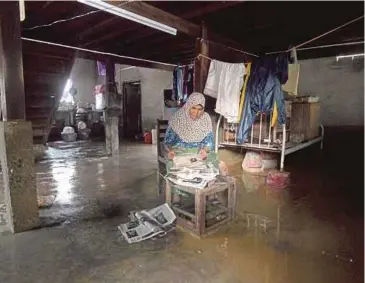  ?? PIC BY AZHAR RAMLI ?? Jahara Hat going through her belongings that were damaged by floodwater­s at her home in Kampung Tebing Tinggi, Kangar, yesterday.