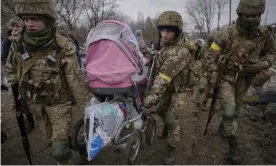  ?? ?? Ukrainian troops helped fleeing civilians cross the Irpin River after a bridge was destroyed by a Russian airstrike. Photograph: Vadim Ghirdă/AP