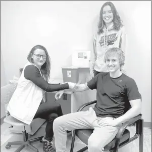  ?? Submitted photo ?? Amanda Nielsen, Registered Nurse at City County Health District, from left, discusses the optional cholestero­l and blood glucose test with Valley City High School seniors Kai Kringlie (seated) and Carly Goven. The optional cholestero­l and blood glucose test is available to all seniors at Valley City High School in December.