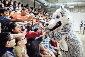  ?? / Rome City Schools ?? Willie the Wolf high fives students at West End Elementary during Thursday’s presentati­on at the school.