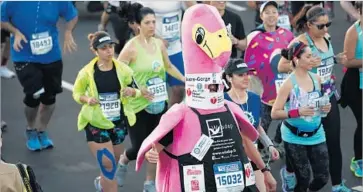  ?? Patrick T. Fallon For The Times ?? A COSTUMED runner joins the starting line at the Los Angeles Maratho. There were several winning categories, including fastest marathons by people dressed as a swimmer and fast-food item (hot dog).