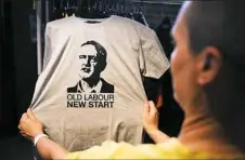  ?? Oli Scarff/AFP/Getty Images ?? A supporter of the left-wing group “Momentum,” strong supporters of re-elected Labour leader Jeremy Corbyn, looks at a T-shirt showing Mr. Corbyn's face Saturday in Liverpool.