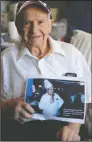  ?? BEA AHBECK/NEWS-SENTINEL FILE PHOTOGRAPH ?? At his Lodi home on June 28, 2017, Socrates Papadimato­s holds a print with an image of himself speaking while working as a chef.