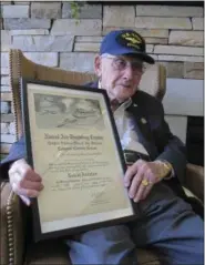  ?? JOHN SEEWER — THE ASSOCIATED PRESS ?? World War II veteran Bob Barger poses with his Naval flight school certificat­e in Toledo. Barger is set to graduate from the University of Toledo after a review of his transcript­s showed he completed enough classes in the late 1940s for a two-year...